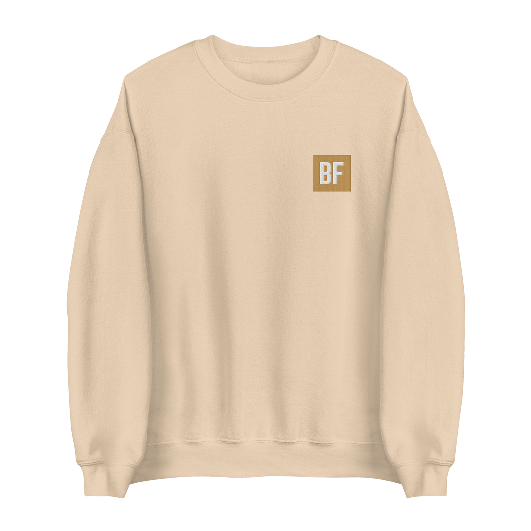 A light beige crewneck sweatshirt with a small square tan chest logo containing the letters 'BF' in white, shown on a plain white background.